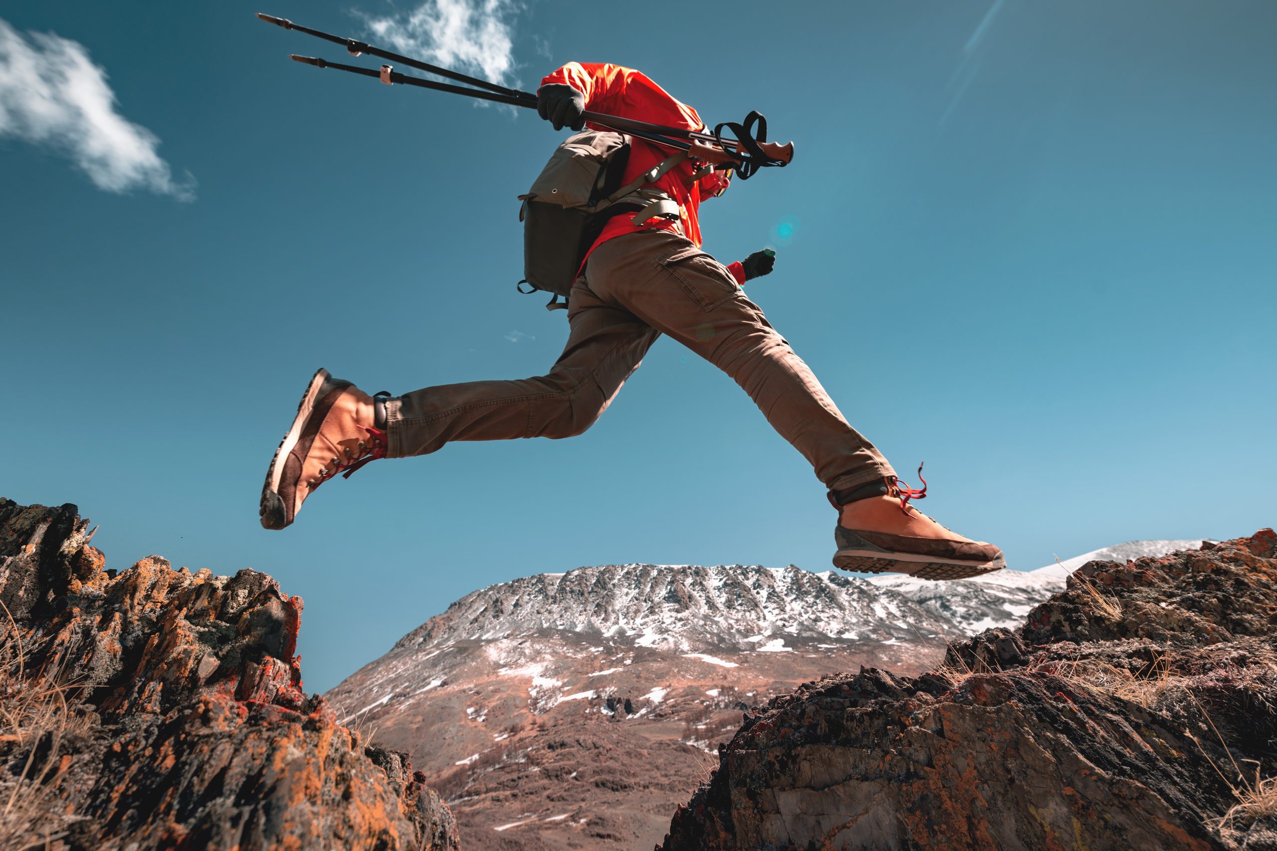 Hiker leaping over a small ravine