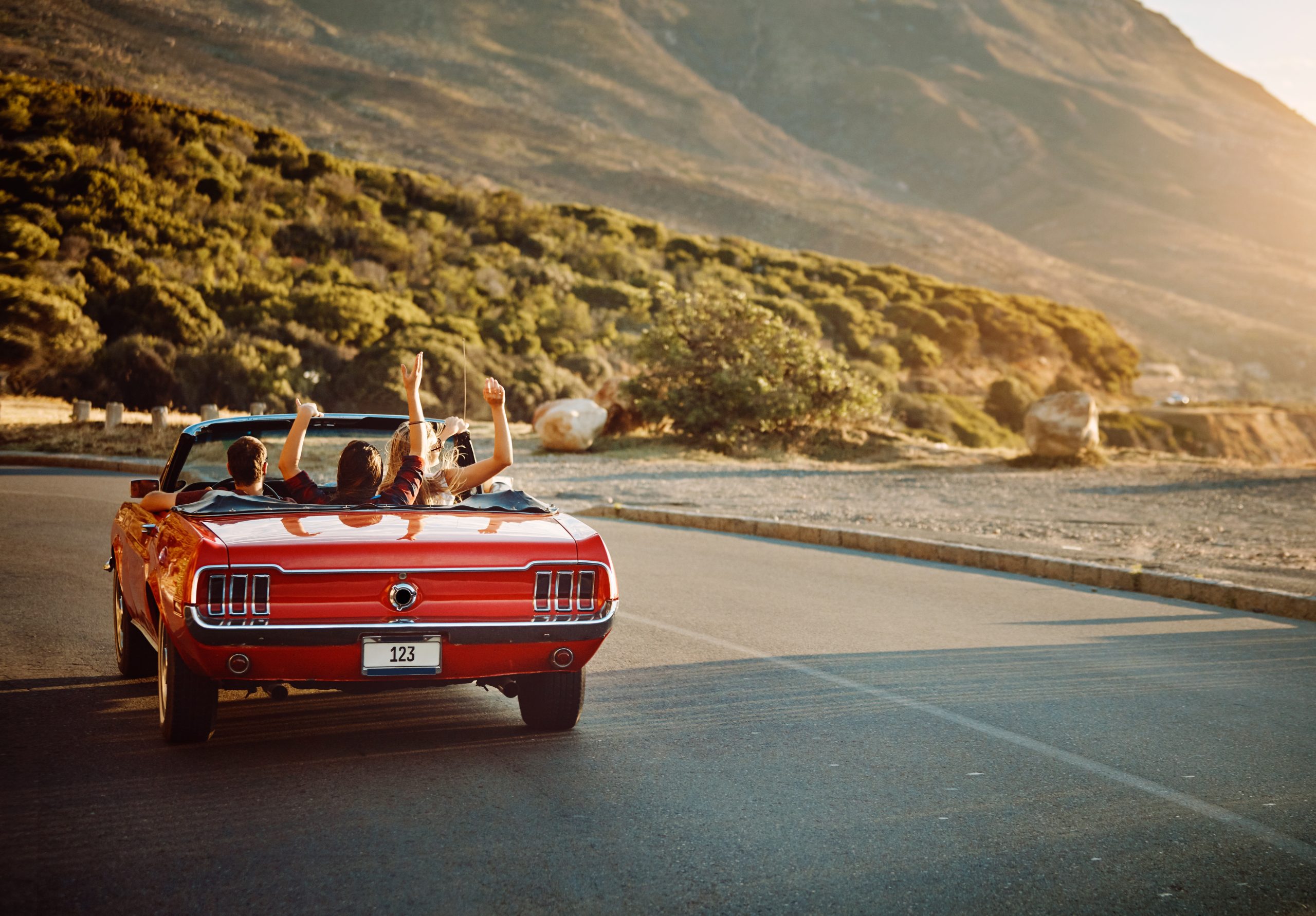 Friends with the roof down in a convertible sports car