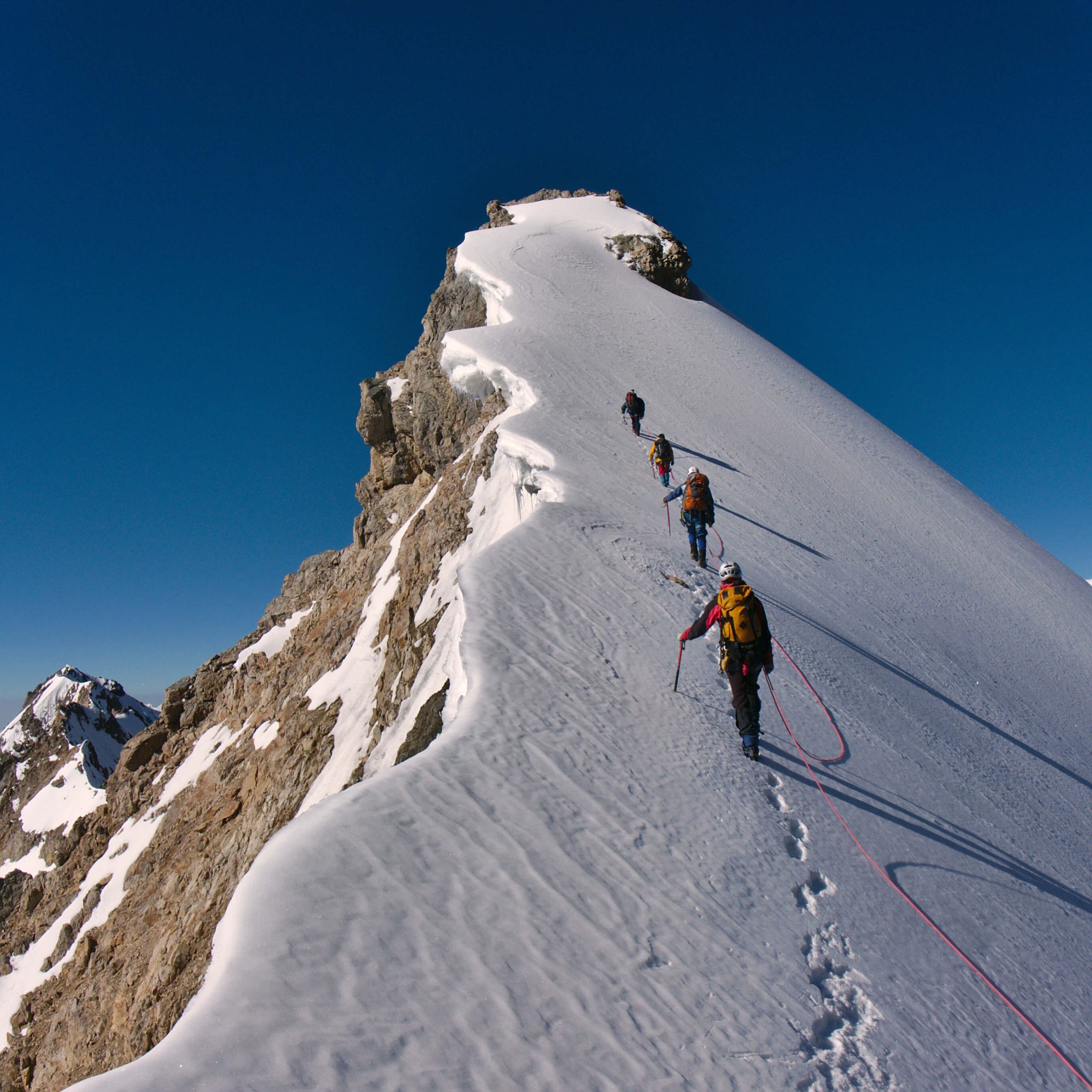 Climbers hiking up a snowy mountain