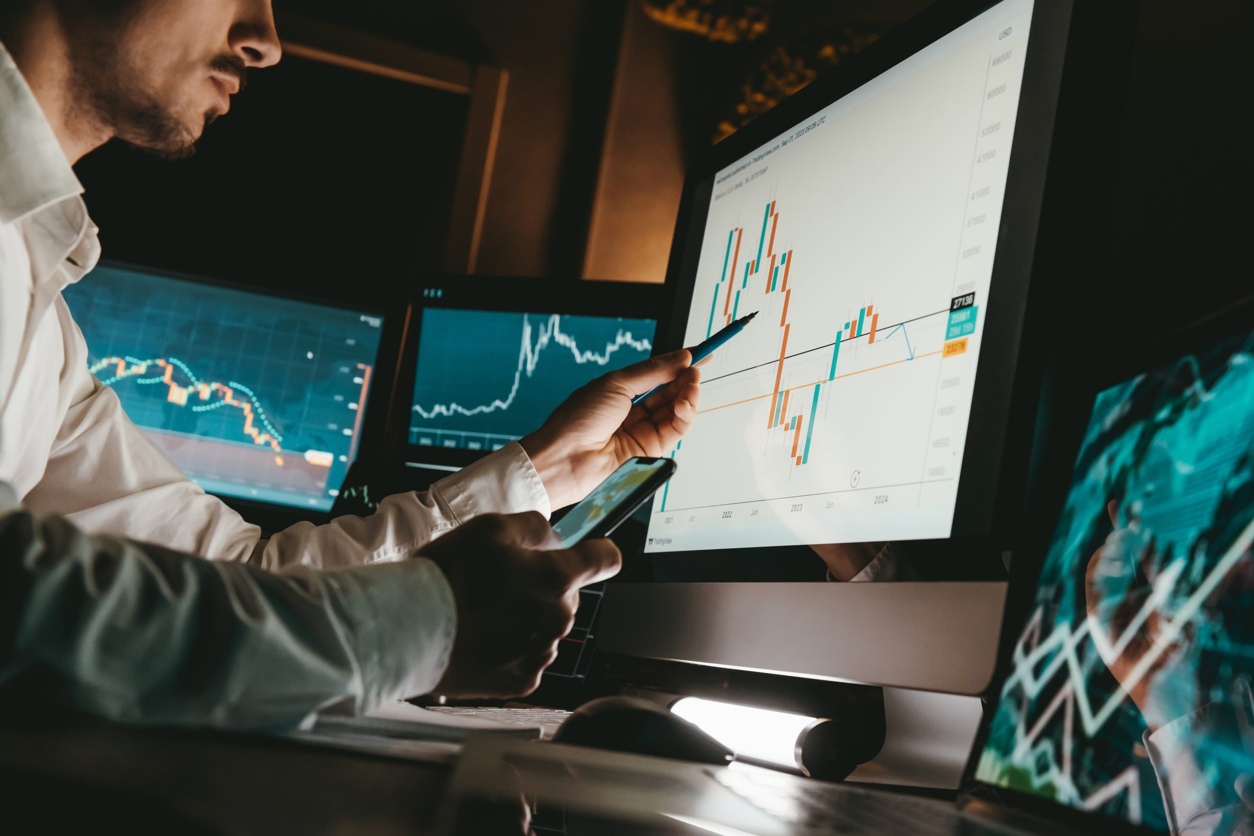 Investment analyst reviewing candlestick graphs