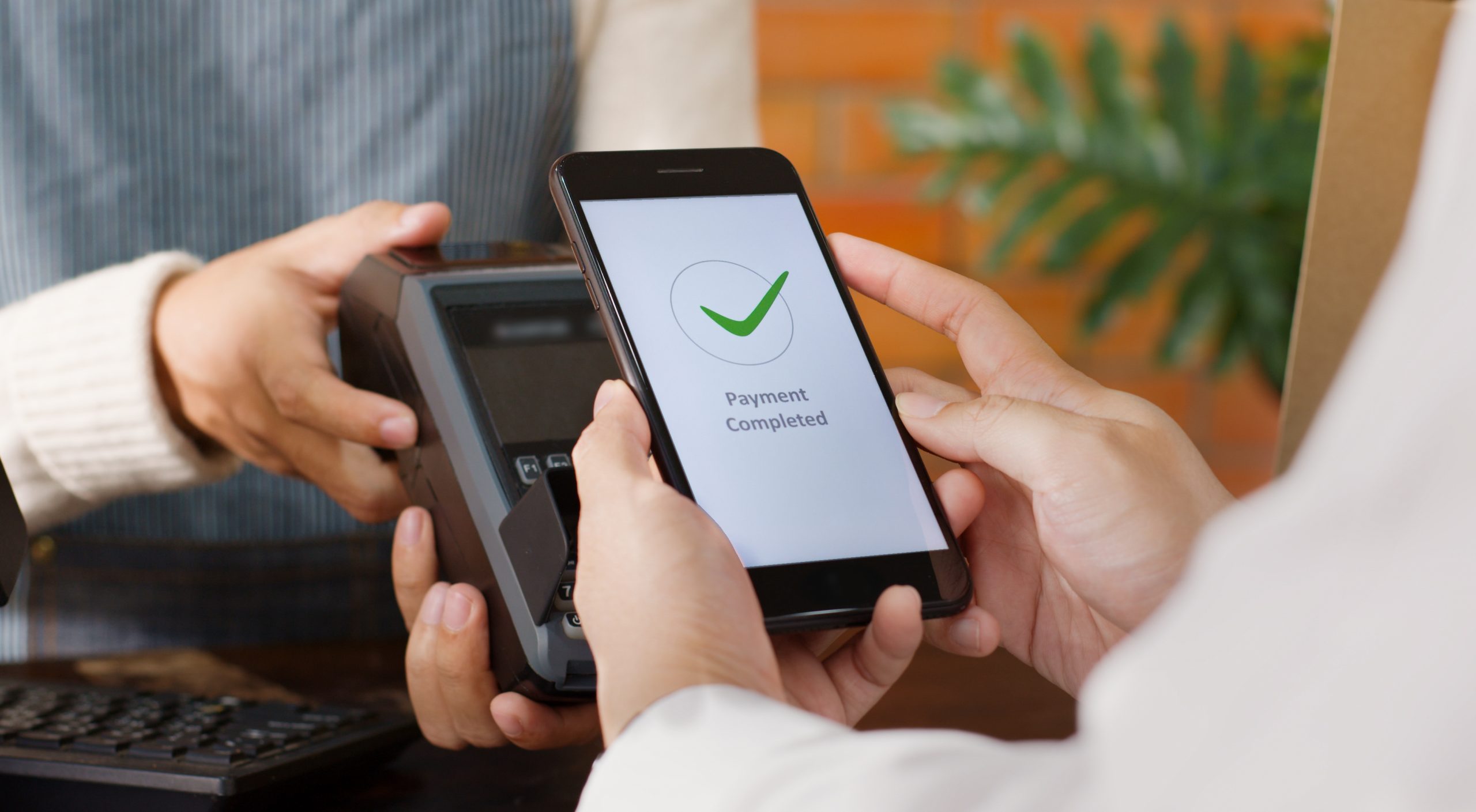 Customer using their mobile phone to pay for goods